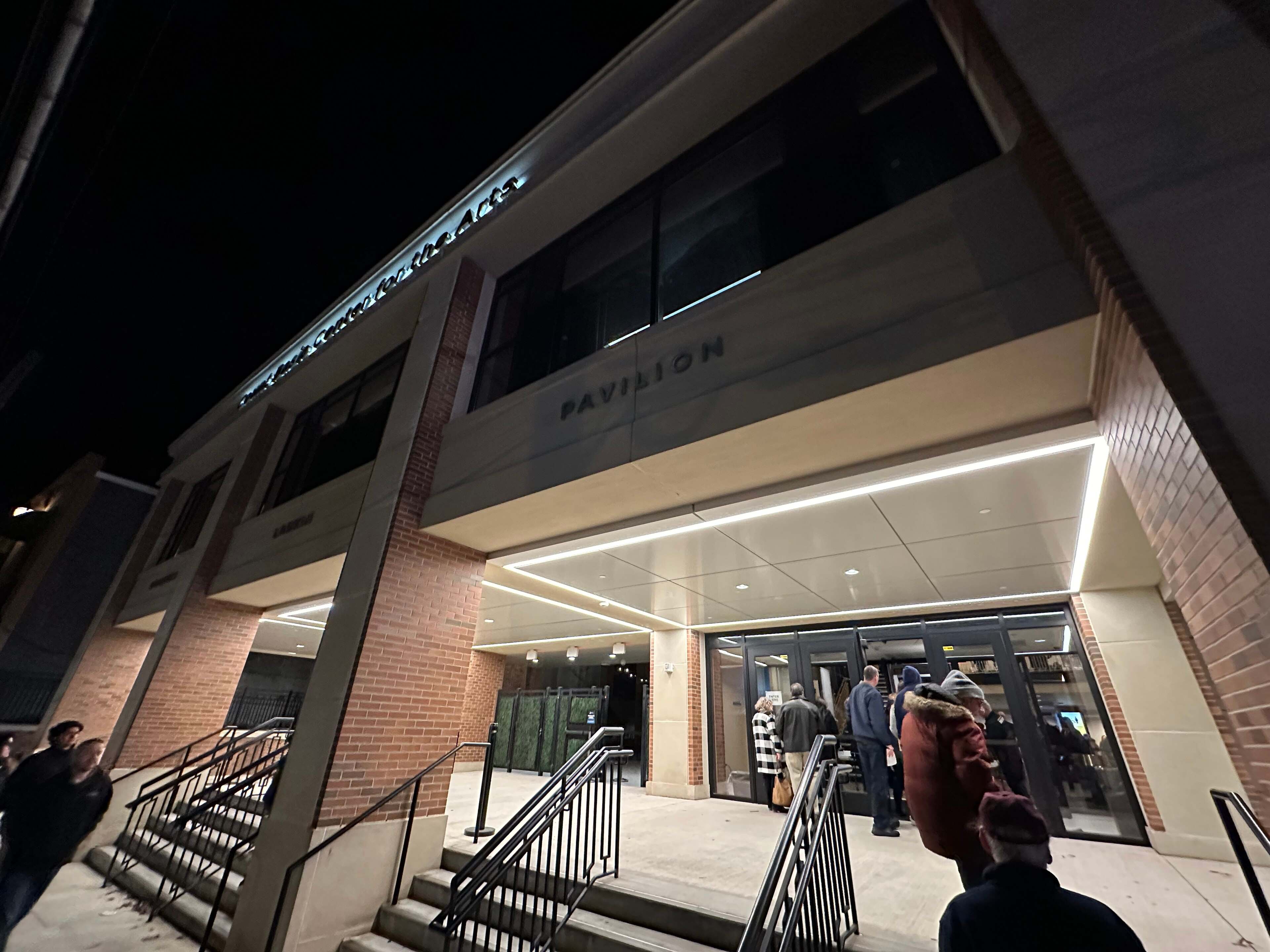 Night view of the Pavilion entrance at the Count Basie Center for the Arts in Red Bank, with people on the steps.
