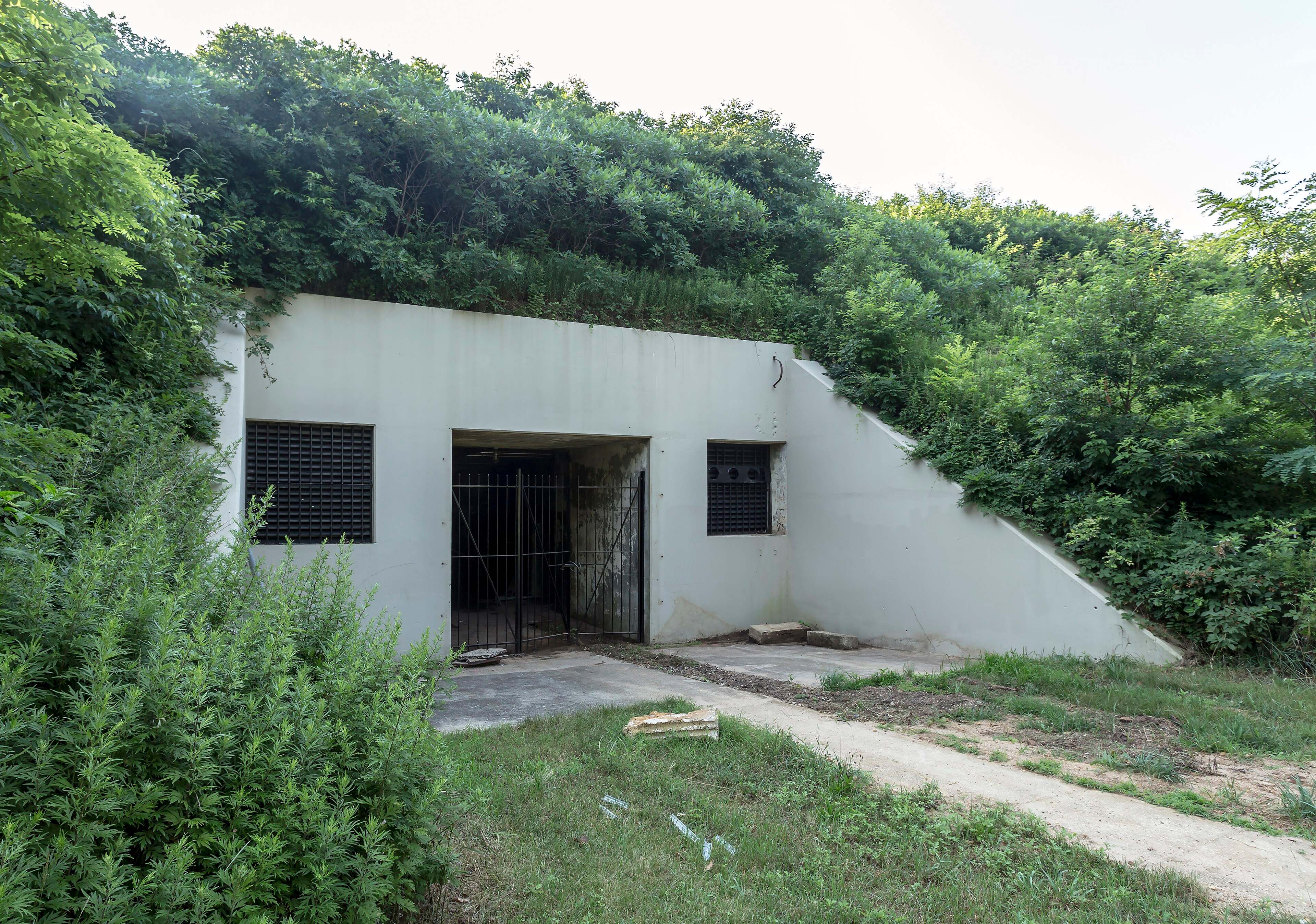 A grass-roofed concrete bunker of Battery Lewis set into a hillside at Hartshorne Woods Park.