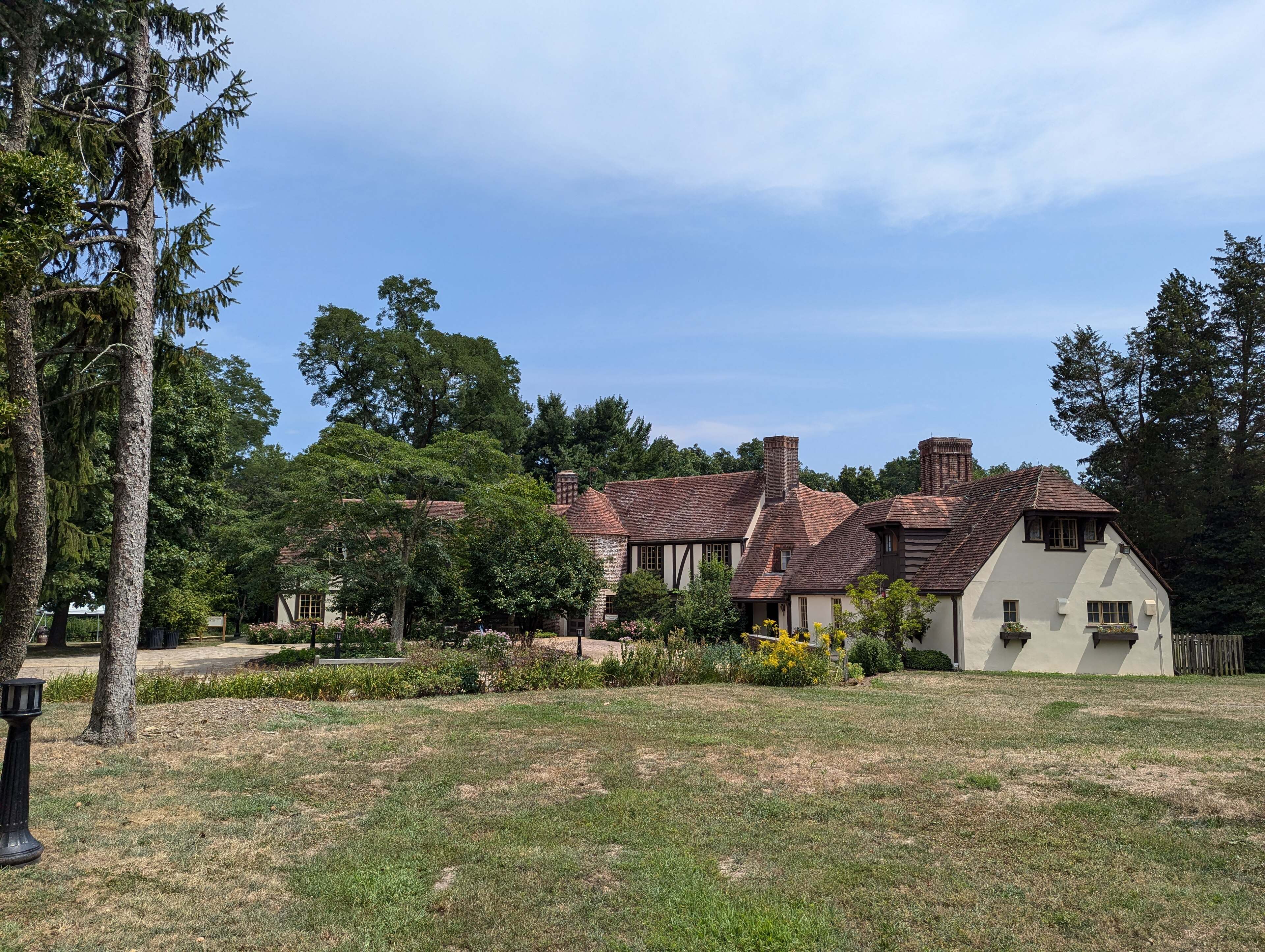 The Tudor-style Environmental Center at Huber Woods Park, set back across a lawn.